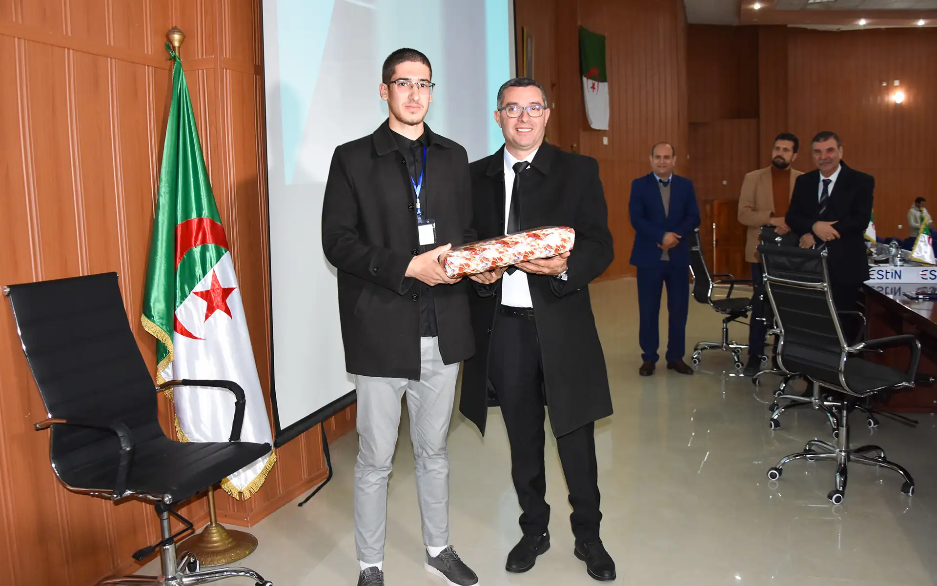 Pr BEKTACHE Mourad remet un prix à un des lauréats du concours organisé à l'occasion de la journée nationale du savoir le 16 avril 2026